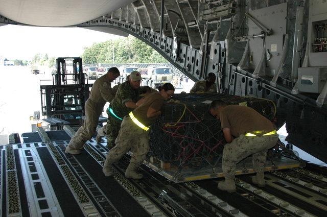 Kanadští vojáci přebírají paletu s municí