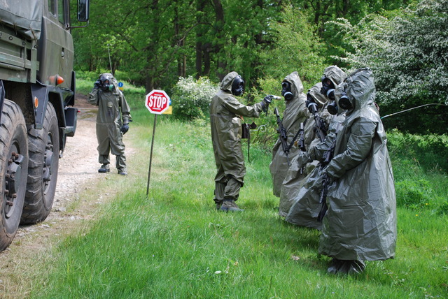 Na roztřiďovacím stanovišti provádí voják dozimetrickou kontrolu osob