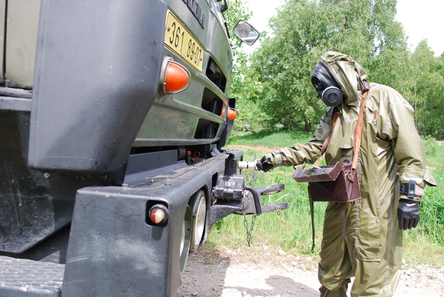 Chemik provádí dozimetrickou kontrolu bojové techniky