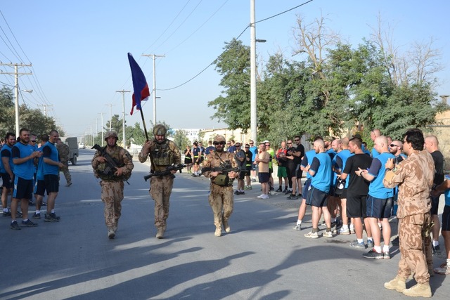 Nadporučík Petr B., nadrotmistr Radim M., rotmistr René T. nesou českou vlajku na základně v Bagrámu