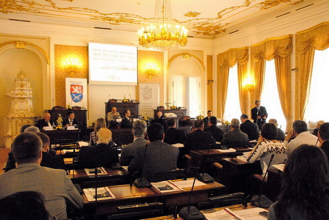 Auditorium konference naslouchá projevu ministra obrany