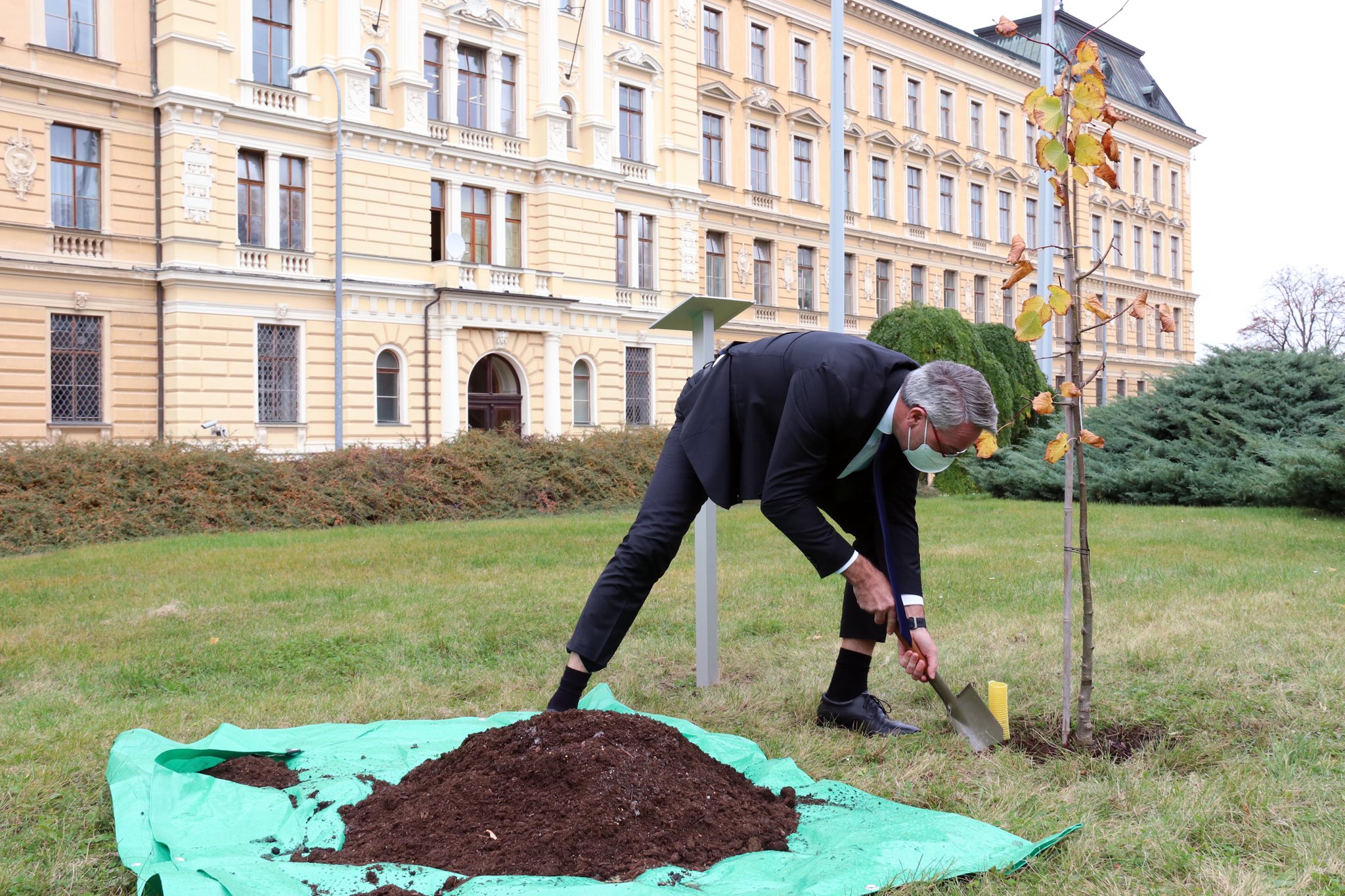 Ministr Metnar před budovou zasadil sazenici Lukasovy lípy. Jak jinak než vojenskou polní lopatkou. 
