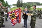Zdeněk Hruška, předseda Československé obce legionářské jednoty Strakonice, dekoruje bojový prapor strakonického pluku pamětní stuhou. 
