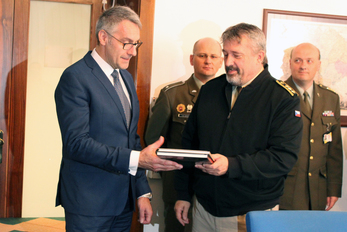 Generálporučík Aleš Opata předává ministrovi Lubomíru Metnarovi dar v podobě publikací