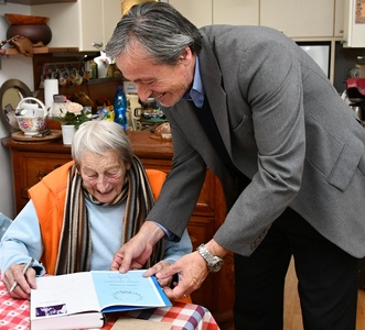 Dana Zátopková ministru obrany podepisuje autorskou knihu Náš život pod pěti kruhy