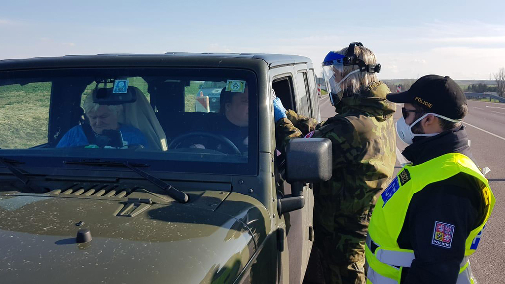 Na hraničních přechodech vojáci měří lidem teplotu, pomáhají určit anamnézu, dezinfikují hasiče v ochranných oblecích. Armáda také poskytla stany a kontejnery (na fotografii hraniční přechod Hatě).