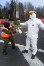 Hraniční přechod Strážný - kontrola a dezinfekce hasiče v ochranném obleku.