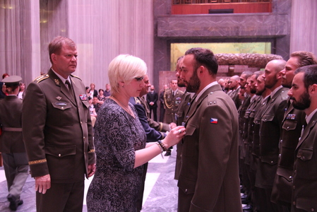 Ministryně obrany Karla Šlechtová předává medaili jednomu z vojáků 9. strážní roty 