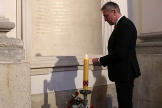 Ministr Lubomír Metnar zapaluje svíčku při modlitbě