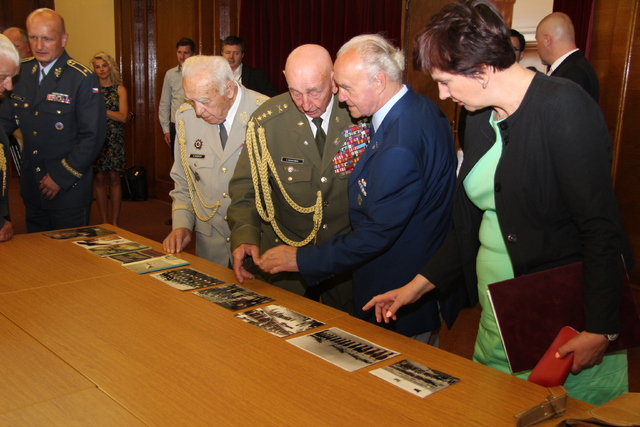 Náměstkyně Netolická si prohlíží dobové fotografie a publikace, které přinesl jeden z účastníků