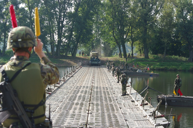 Navádění vozidla na pontonový most (vpravo vzadu na mostu jsou ženisté Národní gardy)