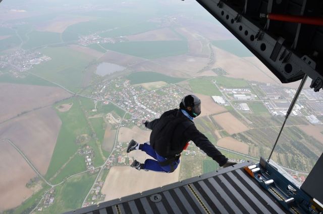 Instruktor výsadkové přípravy praporčík Jiří Kupčík opouští  letoun CASA ve výšce 3000 metrů nad zemí