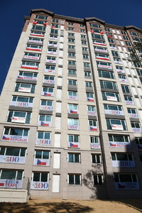 Jeden z domů olympijské horské vesnice. Sedm pater obývají Češi