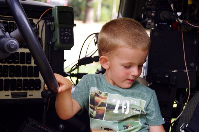 Jeden z dětských návštěvníků si prohlíží vojenskou techniku