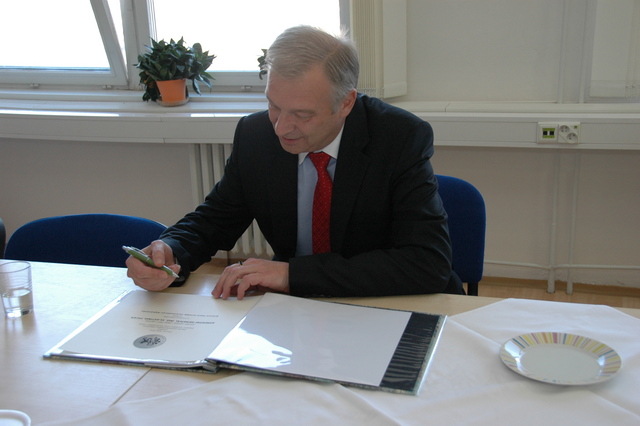 Ministr obrany se podepisuje do pamětní knihy fakulty