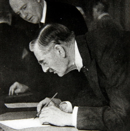 Britský premiér Neville Chamberlain podepisuje Mnichovskou dohodu