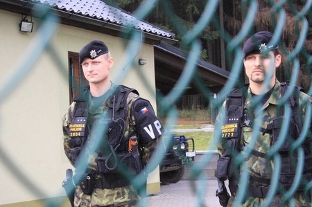 Příslušníci Vojenské policie za vnitřním plotem střeženého prostoru jsou připraveni k zásahu