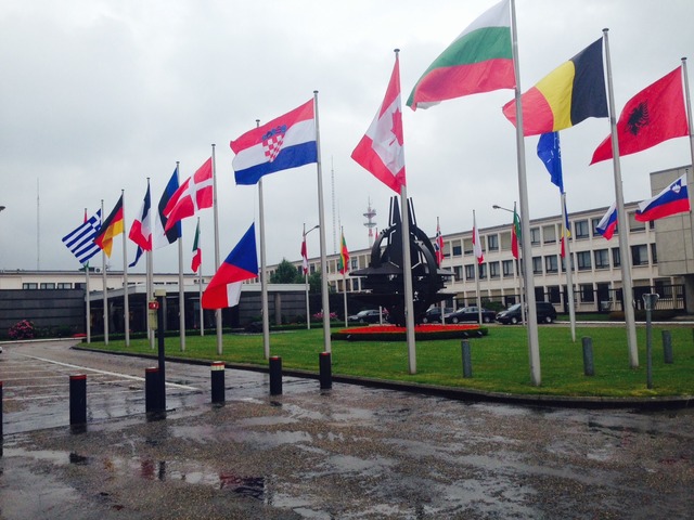 Před centrálou NATO v Bruselu visí česká vlajka na půl žerdi