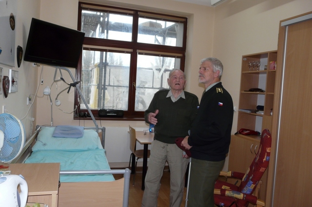 Generál Klemeš ukazuje generálu Pavlovi svůj pokoj a děkuje mu za péči, se kterou se mu věnují příslušníci 4. brigády rychlého nasazení. Na zdi visí nezbytný padák.