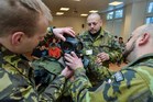 Obléknout protichemický oblek i s maskou není nic jednoduchého, v tomto případě žákovi asistovali tři vojáci