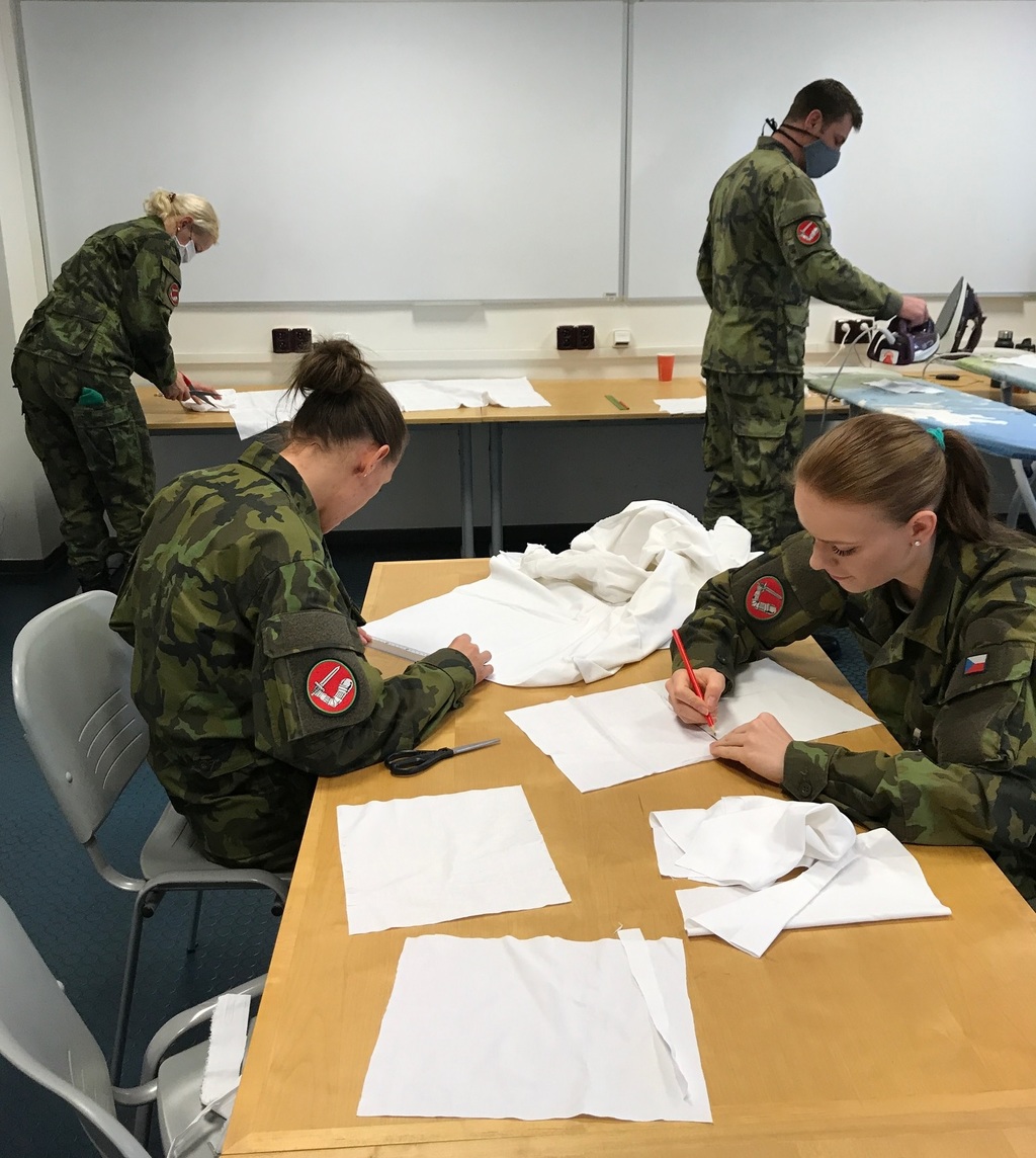 Příslušníci Čestné stráže AČR stříhají a kompletují roušky.