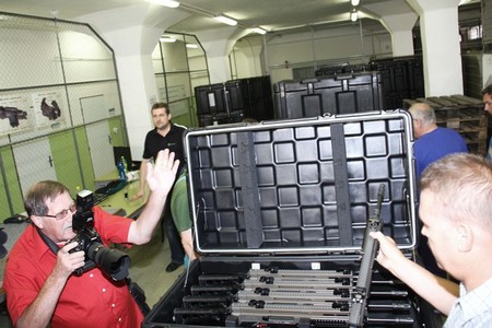 Technici základny předvádějí obsah transportních obalů s novými zbraněmi a jejich příslušenstvím