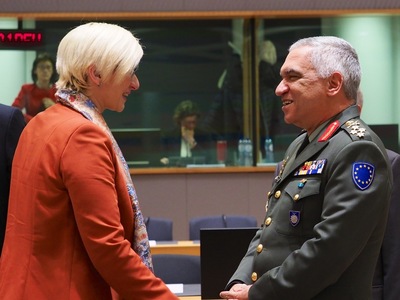 Karla Šlechtová se na jednání rady ministrů obrany Evropské unie zdraví se stálým předsedou Vojenského výboru Evropské unie (EUMC) Michailem Kostarakosem