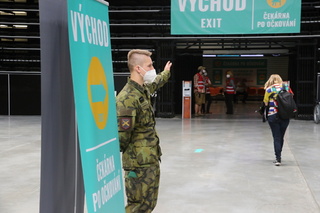 Vojáci lidem ukazují, kam mají jít a případně asistují hůře pohyblivým.