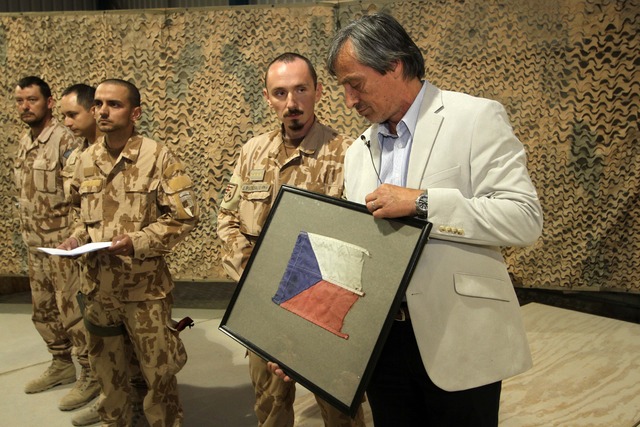 Ilustrační fotografie: Ministr obrany Martin Stropnický během návštěvy českých vojáků v Afghánistánu vloni v červenci. Návštěva se uskutečnila týden po sebevražedném atentátu, při kterém čtyři vojáci zemřeli a jeden později podlehl svým zraněním v nemocnici. Čeští vojáci darovali ministrovi vlajku z výbuchem poškozeného obrněnce. 
