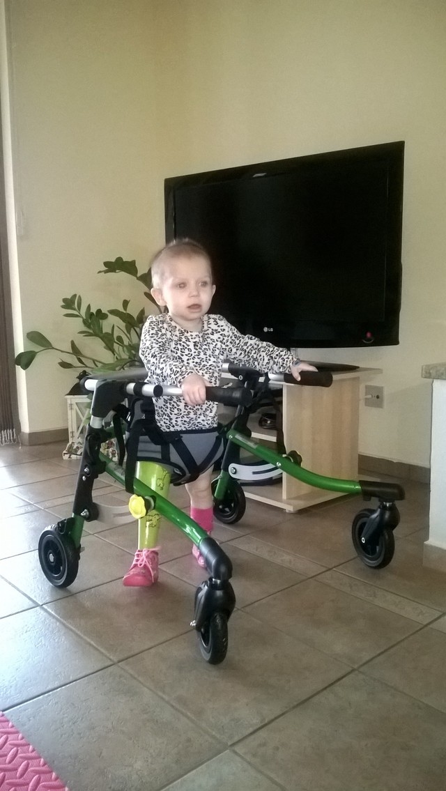 Markétka v chodítku, pomocí kterého se učí chodit s protézou dolní končetiny